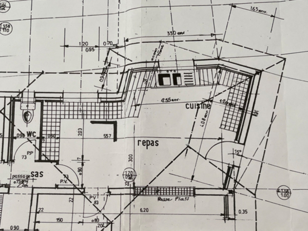 Detailed top-down architectural layout of a kitchen featuring a central dining table surrounded by chairs, adjacent to a modern kitchen island with integrated appliances and precise dimensions annotated. Discover the precision and innovation behind this kitchen layout designed for optimal functionality and social interaction. The architectural plan presents a unique top-down view, meticulously detailing every element of the space. At the heart of the layout is a central dining table surrounded by six chairs, positioned strategically to foster communal dining experiences. Adjacent to the dining area is a modern kitchen island equipped with high-tech appliances and ample preparation space, providing a practical and stylish cooking environment. The layout includes detailed dimensions, ensuring a practical guide for renovation or construction purposes. This design maximizes the use of space while promoting a welcoming atmosphere, ideal for those who love to entertain guests or enjoy family meals in a beautifully organized kitchen setting.