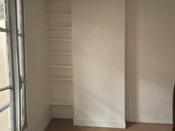 A simple and serene corner of a room with a large window, bare white walls, and floating shelves waiting to be adorned. This image captures the quiet potential of a minimalist space, bathed in natural light from the adjacent window. The stark white walls, punctuated by a sequence of empty floating shelves, offer a blank canvas inviting creativity and personalization. The subtle shadow play on the walls, coupled with the soft glow of daylight, adds depth and dimension to the unadorned alcove. This tranquil corner is a testament to the beauty of simplicity, providing a calm respite from the busy world outside and a promise of transformation with just a touch of decorative flair.