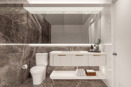 Contemporary bathroom featuring marble walls in rich dark tones, a sleek white vanity with integrated sink, and a toilet beside neatly arranged towels. This rendering showcases a contemporary bathroom design that epitomizes luxury and functionality. The space is defined by dark, richly veined marble walls that contrast beautifully with a sleek, white floating vanity. Above the vanity, a large mirror spans the length of the wall, enhanced by a horizontal light strip that adds a bright, clean glow, perfect for grooming tasks. Adjacent to the vanity, the toilet area is discreetly designed with accessibility in mind, complete with a stack of fresh towels housed in an open shelf, enhancing the room's practicality without sacrificing style. This bathroom design effectively combines elements of modern design with practical solutions, making it an ideal choice for those seeking a refined yet functional living space.