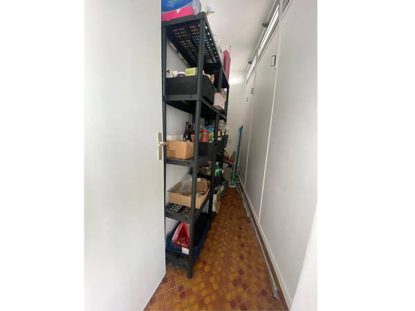 A narrow, cluttered closet before a makeover.