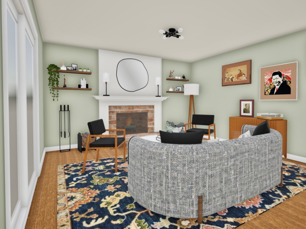 Living room with a curved gray sofa, black chairs, a brick fireplace, floating shelves with plants and decor, and framed artwork on the walls. A record player and wood sideboard add to the cozy atmosphere.